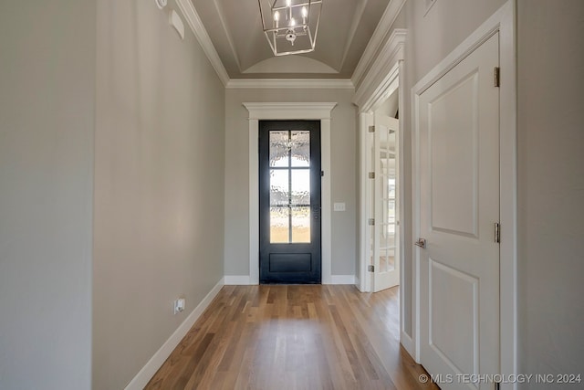 doorway to outside featuring light hardwood / wood-style flooring, a chandelier, and ornamental molding