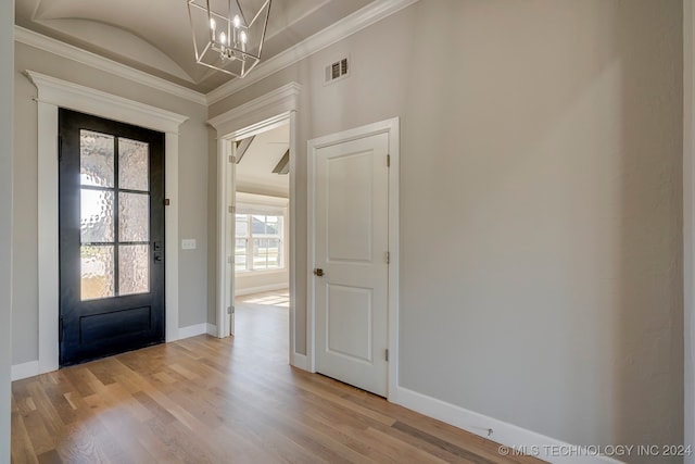 foyer entrance with a chandelier, light hardwood / wood-style floors, and crown molding