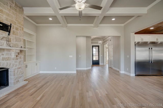 unfurnished living room with light wood-type flooring, a stone fireplace, coffered ceiling, and beamed ceiling