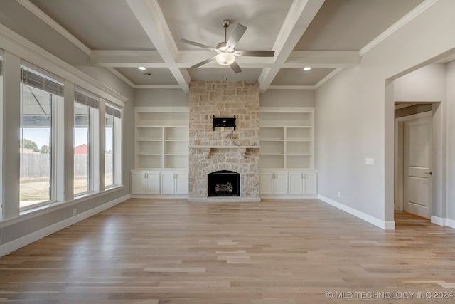 unfurnished living room with coffered ceiling, a stone fireplace, beamed ceiling, ceiling fan, and light hardwood / wood-style flooring