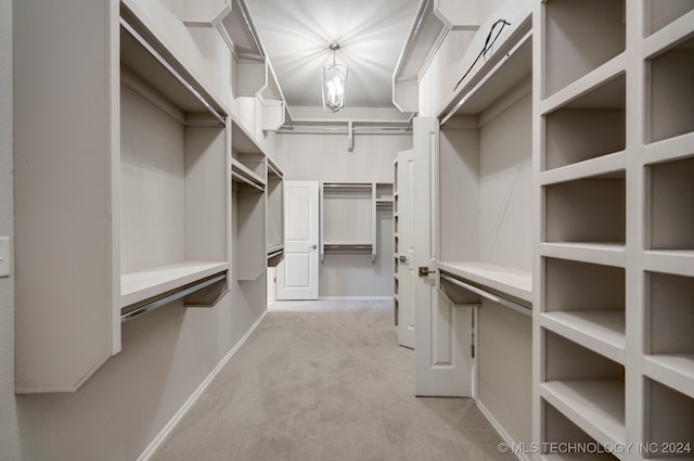 walk in closet with light carpet