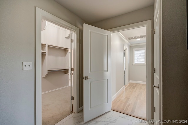 corridor featuring light carpet and ornamental molding