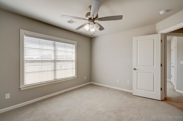 carpeted spare room with ceiling fan