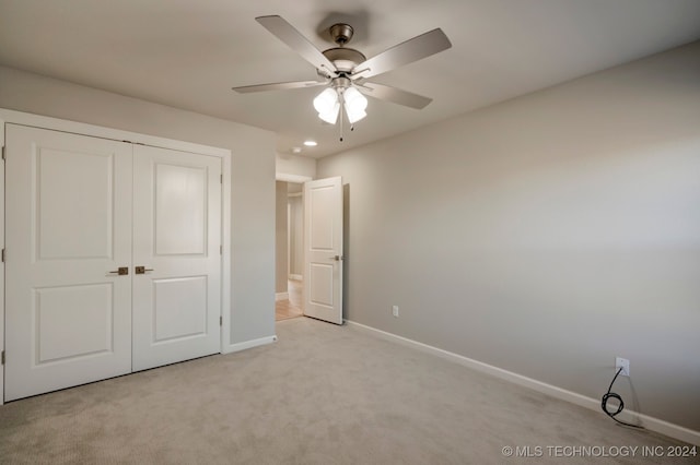 unfurnished bedroom with a closet, ceiling fan, and light colored carpet