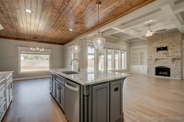 kitchen with an island with sink, hanging light fixtures, sink, dishwasher, and light wood-type flooring