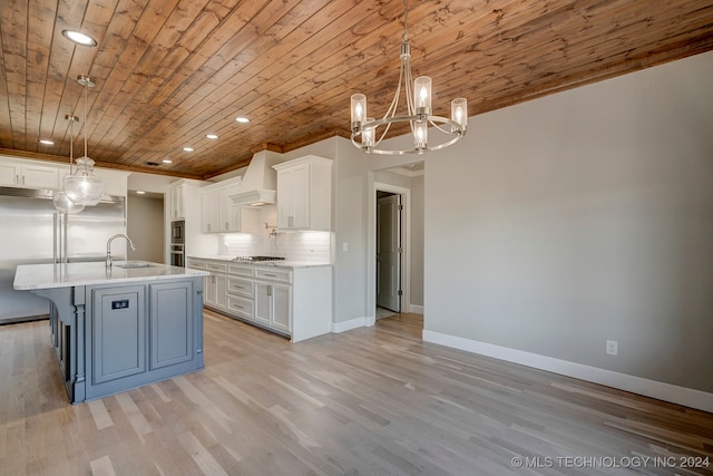 kitchen featuring an island with sink, white cabinets, hanging light fixtures, custom exhaust hood, and wooden ceiling