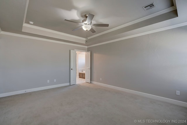 carpeted spare room featuring ceiling fan, a raised ceiling, and ornamental molding