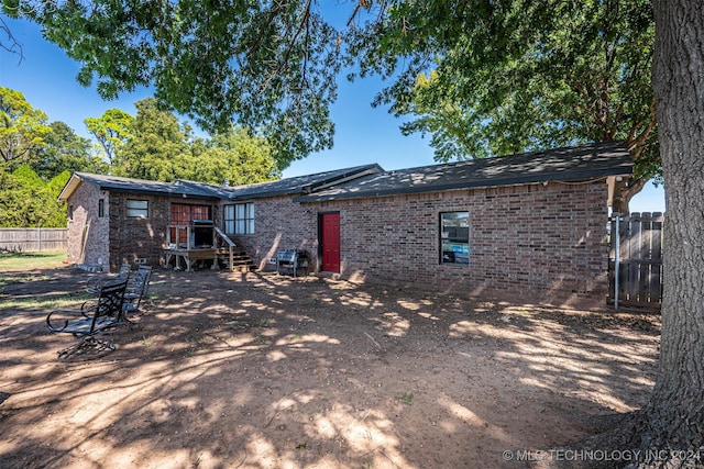 1202 N Pine St, Waurika, OK 73573 - rear view of house with brick siding and fence