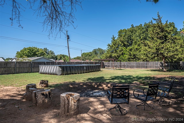 view of yard with a covered pool and a fire pit