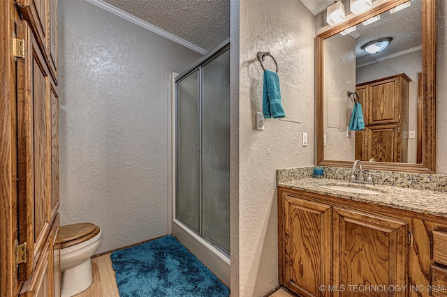 bathroom featuring crown molding, vanity, toilet, and a shower with door