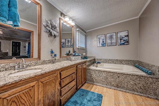 bathroom with vanity, a bathtub, wood-type flooring, a textured ceiling, and crown molding