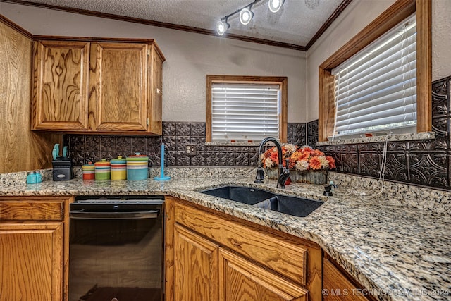 kitchen with light stone counters, ornamental molding, a textured ceiling, and sink