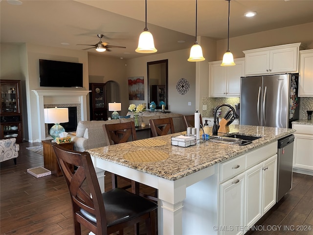 kitchen featuring a kitchen island with sink, stainless steel appliances, and a high end fireplace