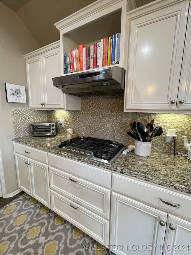 kitchen with stainless steel gas stovetop, vaulted ceiling, decorative backsplash, extractor fan, and stone countertops