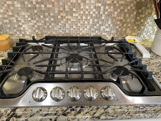 details with backsplash and stainless steel gas cooktop