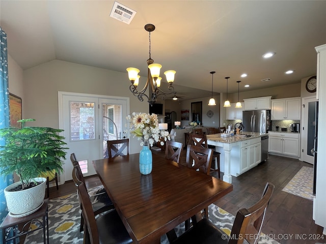 dining area featuring ceiling fan with notable chandelier, lofted ceiling, sink, and dark hardwood / wood-style flooring