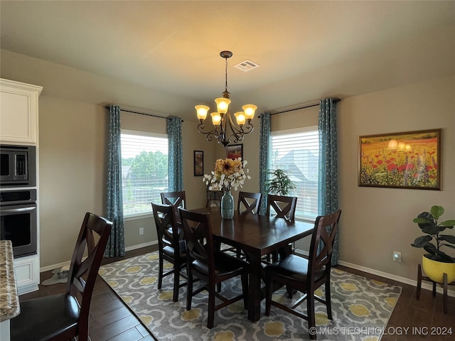 dining space featuring an inviting chandelier and dark wood-type flooring