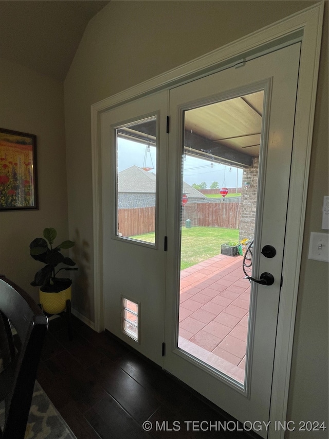 doorway to outside featuring lofted ceiling and dark hardwood / wood-style flooring