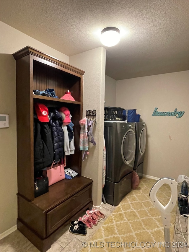 laundry room featuring a textured ceiling, carpet floors, and washing machine and dryer