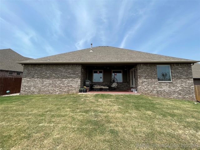 rear view of property with a lawn and a patio