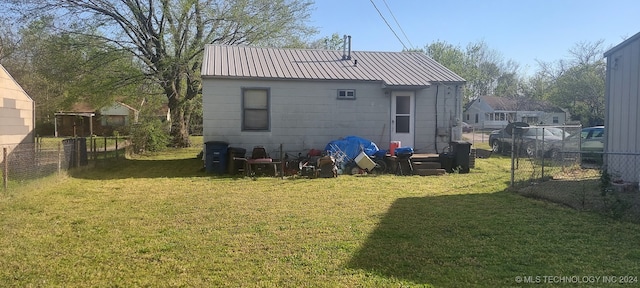 rear view of property featuring a lawn