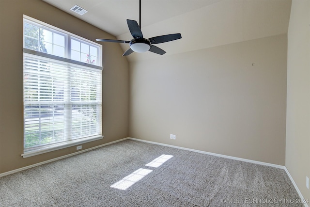 carpeted spare room with ceiling fan and vaulted ceiling