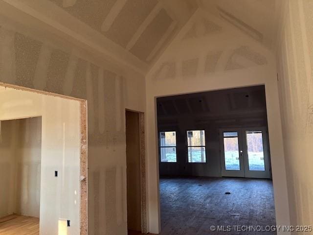 carpeted empty room featuring high vaulted ceiling and french doors