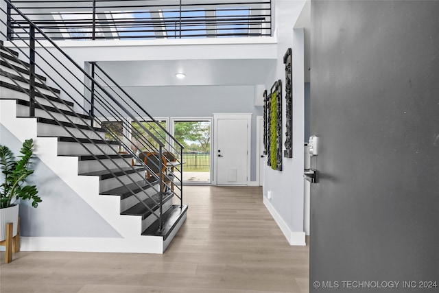 entryway with a high ceiling and light hardwood / wood-style flooring