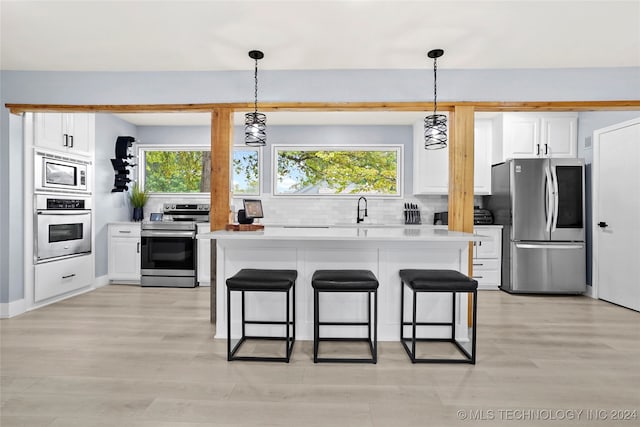 kitchen featuring backsplash, sink, stainless steel appliances, and white cabinets