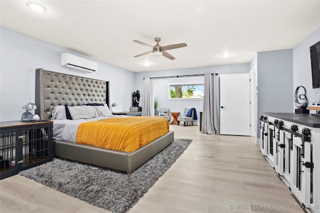 bedroom with light wood-type flooring, ceiling fan, and a wall unit AC