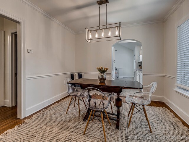 dining area featuring plenty of natural light, ornamental molding, and wood-type flooring