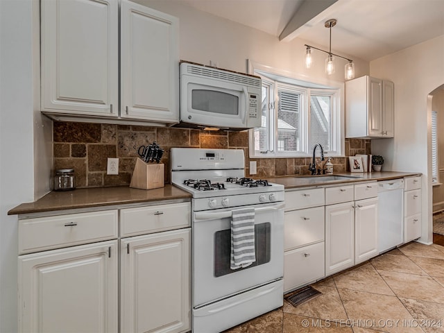 kitchen featuring white cabinets, light tile patterned floors, sink, white appliances, and decorative light fixtures