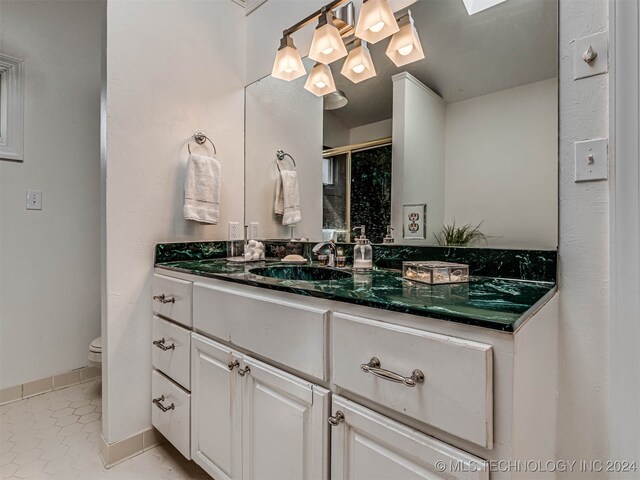 bathroom featuring vanity, toilet, an enclosed shower, and tile patterned floors