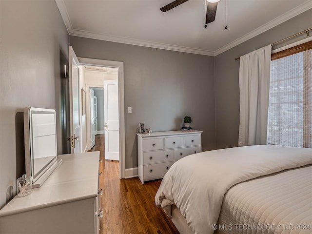 bedroom featuring dark wood-type flooring, ornamental molding, and ceiling fan