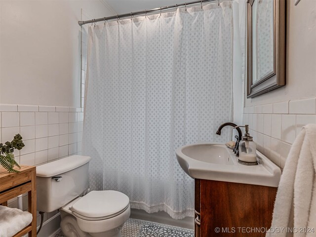 full bathroom featuring vanity, tile walls, toilet, and shower / tub combo with curtain