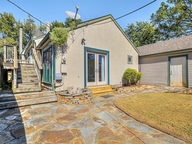 rear view of house with a yard, a patio, and french doors