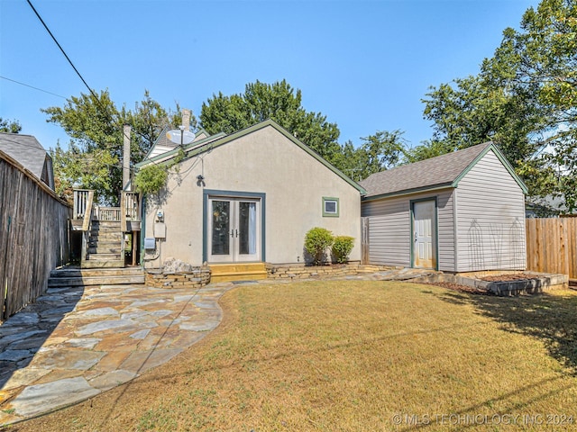 back of property featuring a yard, a storage unit, and a patio area