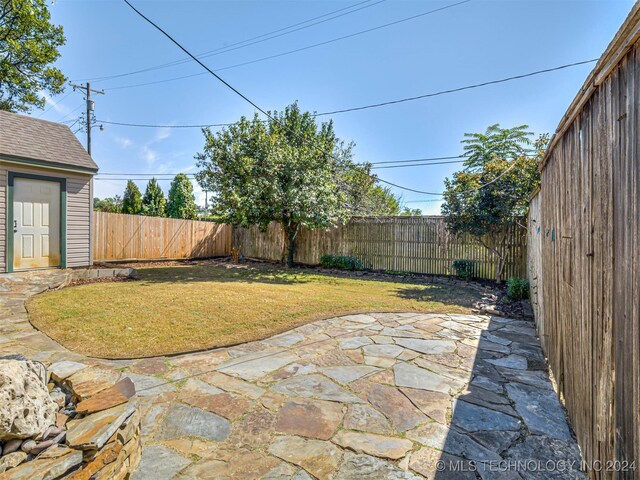 view of yard with a storage shed and a patio area