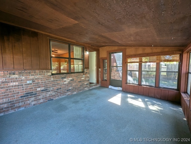 unfurnished sunroom featuring wood ceiling and vaulted ceiling