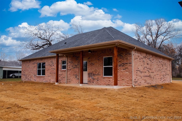 back of property featuring a lawn and a patio area