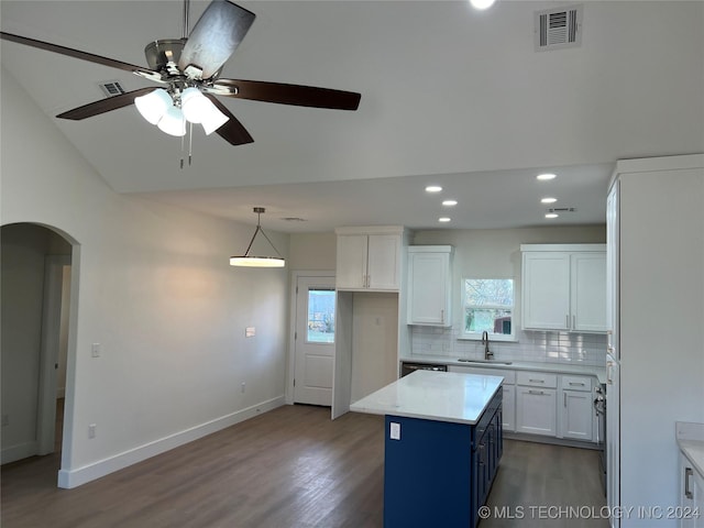 kitchen featuring vaulted ceiling, ceiling fan, wood-type flooring, white cabinets, and a center island