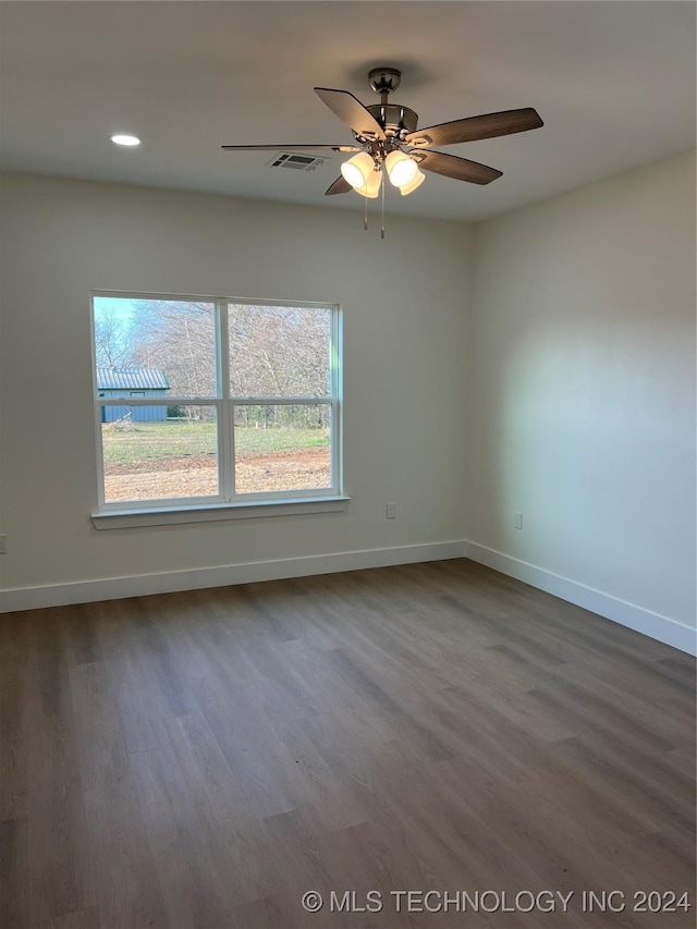 spare room with ceiling fan, dark hardwood / wood-style flooring, and a wealth of natural light