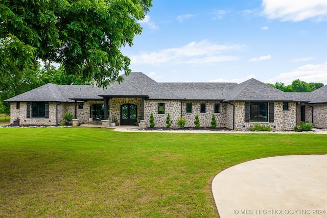 ranch-style house featuring stone siding, french doors, a shingled roof, and a front yard