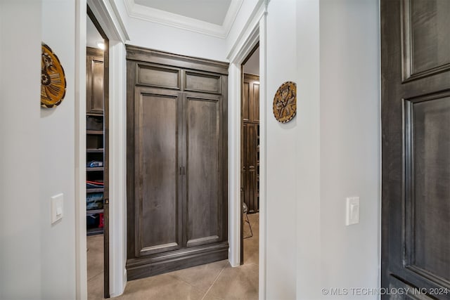 corridor with ornamental molding and light tile patterned floors