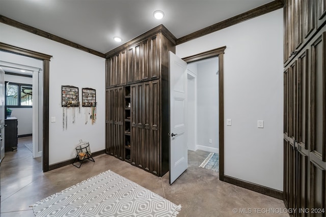 interior space featuring baseboards, concrete flooring, recessed lighting, and crown molding