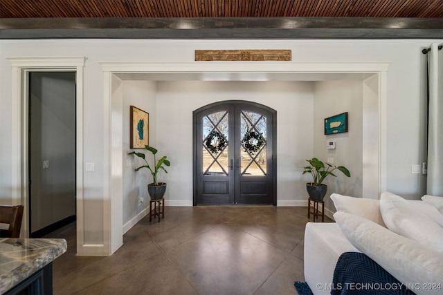 foyer featuring french doors, arched walkways, wood ceiling, baseboards, and finished concrete floors