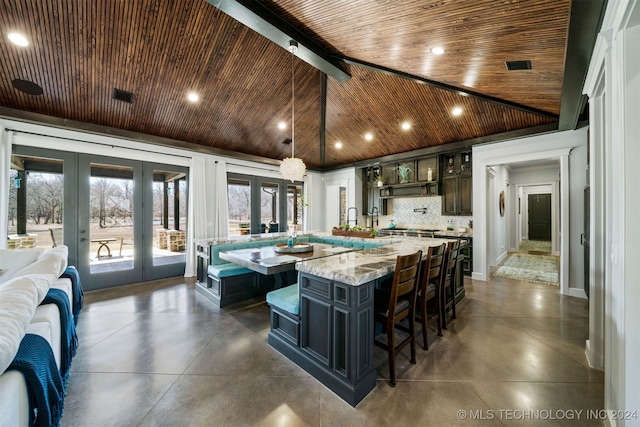 kitchen featuring a large island with sink, finished concrete floors, french doors, wooden ceiling, and recessed lighting