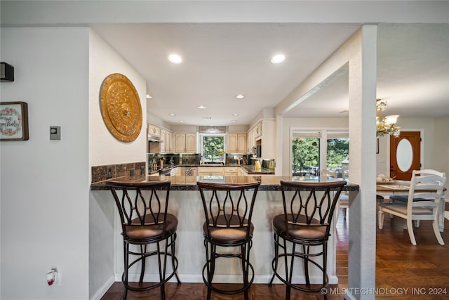 kitchen with an inviting chandelier, dark hardwood / wood-style floors, kitchen peninsula, and a wealth of natural light