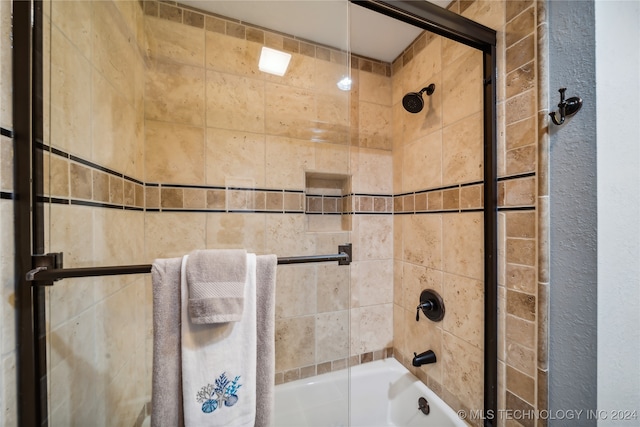 bathroom with combined bath / shower with glass door