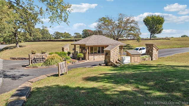 view of front of home with a front yard and a rural view